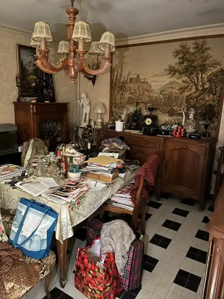Salle à manger encombrée avant un débarras, avec meubles anciens, vaisselle, documents et objets divers à trier et valoriser