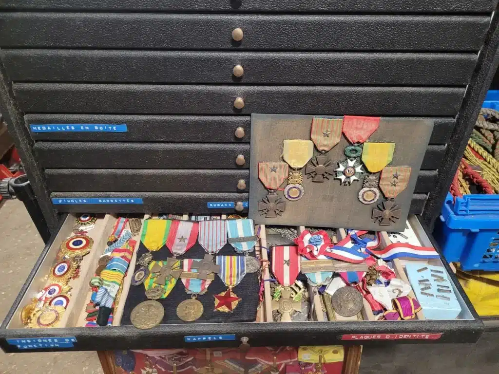 Collection de médailles militaires anciennes, décorations, insignes et rubans de différentes époques. Objets anciens de collection pour passionnés d’histoire. ​​